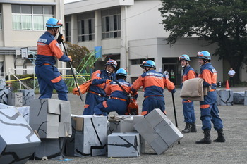写真：倒壊した家屋から瓦礫を撤去する消防団