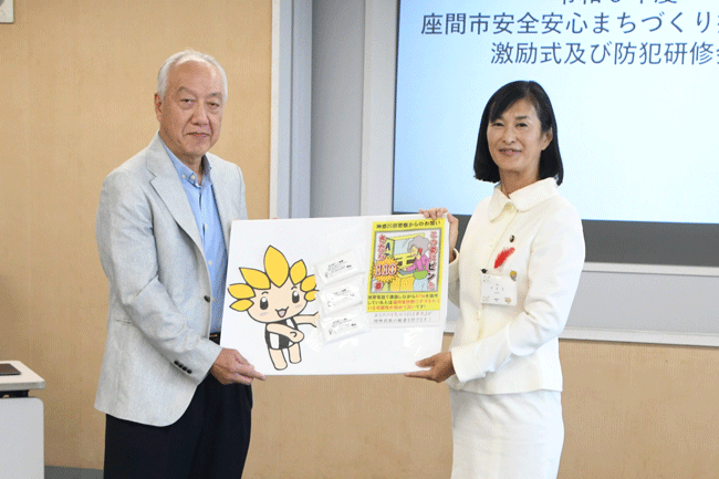 写真：座間自治会総連合会防犯担当役員の谷口好孝さん（左）と市長