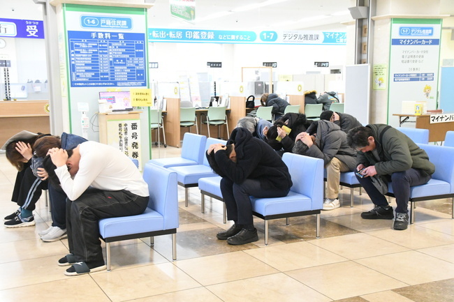 写真：姿勢を低くして頭を守る来庁者1
