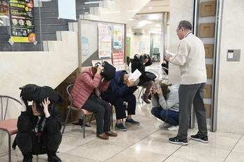 写真：姿勢を低くして頭を守る来庁者2