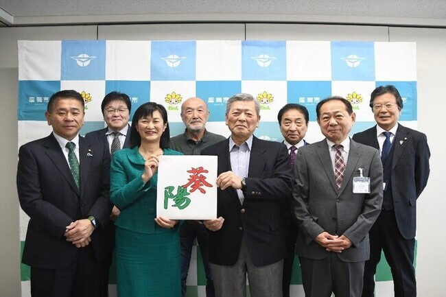 写真:決定した凧文字「あおひ」を持つ市長と凧文字選考委員