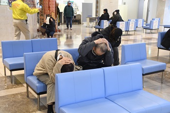 写真：姿勢を低くして頭を守る来庁者の女性と男性