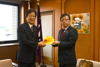 写真：男の子用帽子の寄贈を受ける教育長