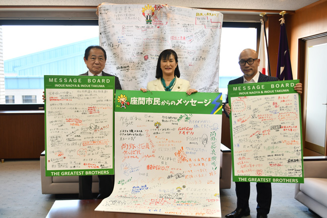 写真:メッセージを後援会会長のくどうさんに贈呈する様子