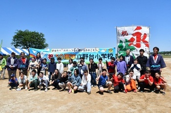 1間凧「永続」の前で撮影した立野台小学校児童たちの記念写真。「祝50周年立野台小学校」と書かれた横断幕が掲げられている