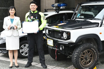 写真：市長ともりやほうたさんが青色回転灯等装備車と並ぶ様子