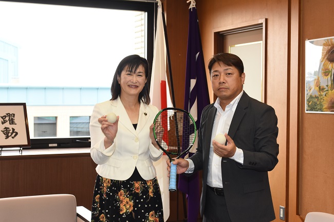写真:(左から)市長、まんとく てつのりさんがラケットとボールを持ち、並ぶ様子