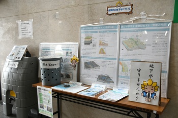 写真：座間市の地下水についての展示。雨水貯留槽、雨水浸透ますのレプリカや、地下水に関するパネルが展示されているほか、リーフレットなどが設置されています。
