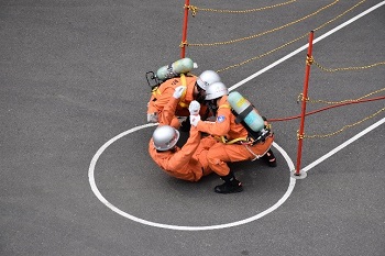写真:隊員2人が、要救助者役の隊員を運ぶ様子
