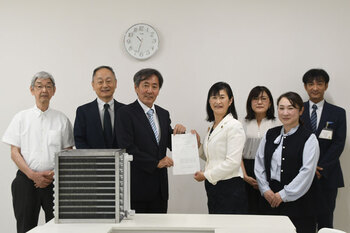 写真：市長とえんどうさんが交付状を持って並んでおり、その周りに三協空調システムの職員と市地域づくり部長が並んでいる様子