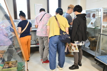 写真：5人の来室者が常設展示室の展示を見ている様子
